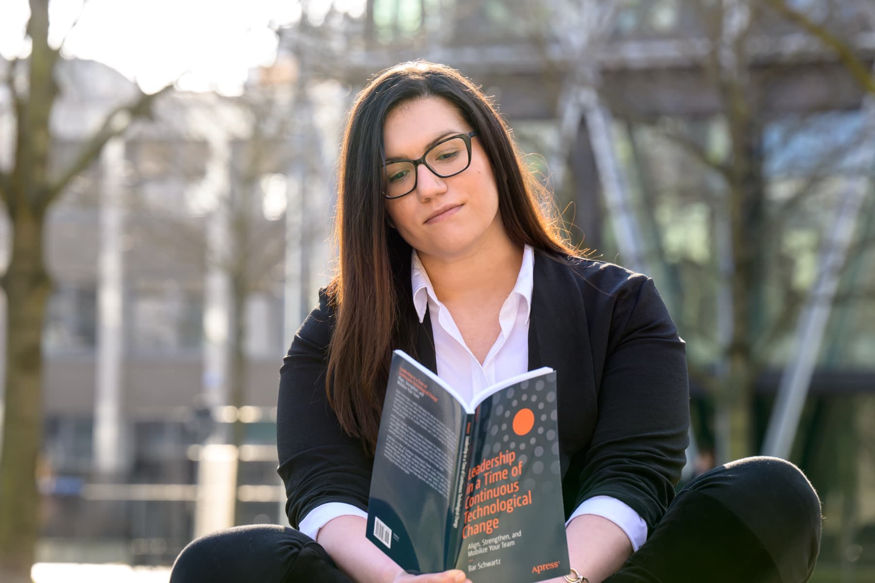 Bar Schwartz, sitting outside an office building, reading Leadership in a Time of Continuous Technological Change